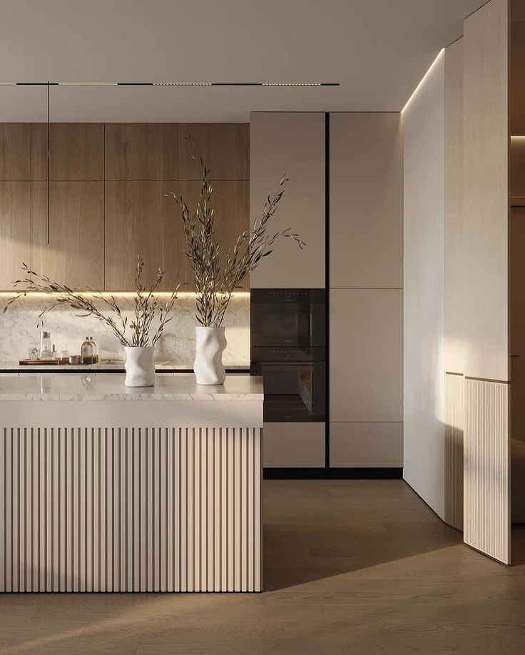 a modern kitchen with marble counter tops and wooden cabinets, along with white vases on the island