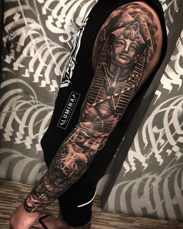 a man's arm with an egyptian tattoo on the left side of his body