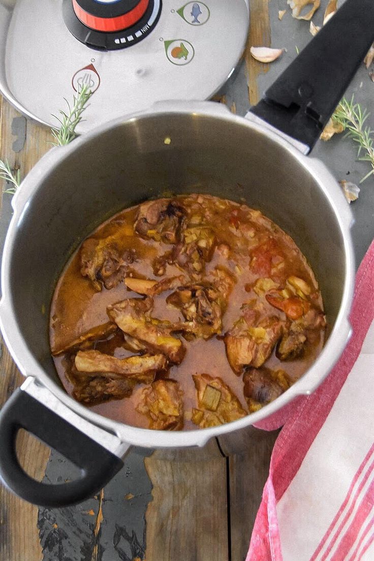 a pot filled with food sitting on top of a wooden table