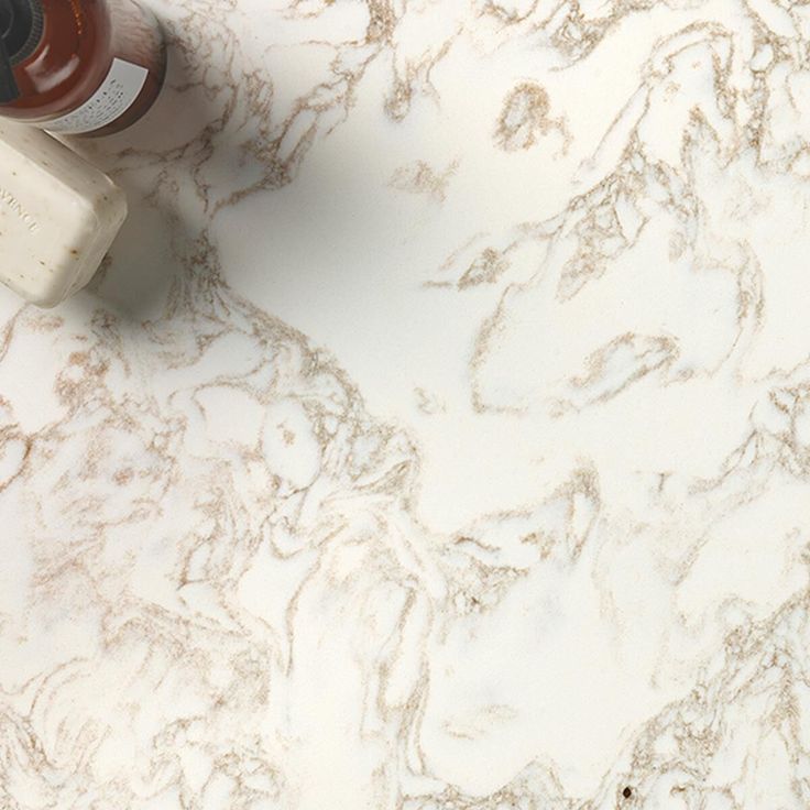 a white marble counter top with an orange and some other items on the countertop