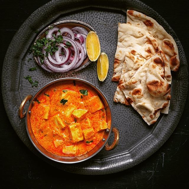 a plate with some food on it next to a bowl of soup and sliced onions