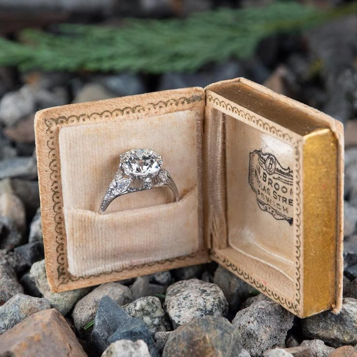 an open ring box sitting on top of rocks