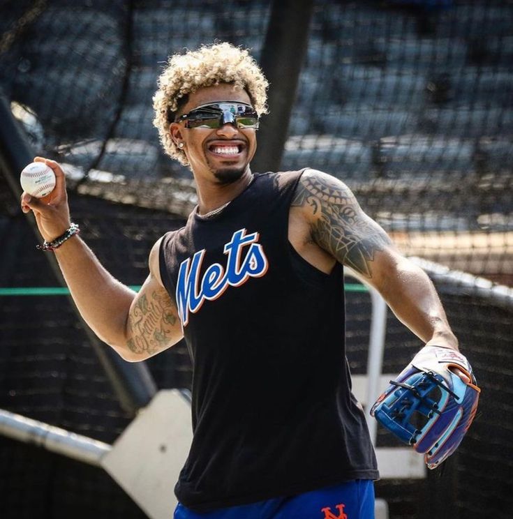 a man holding a baseball in his right hand and wearing a catchers mitt