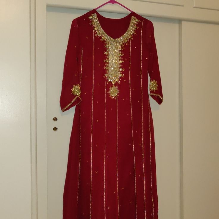 Beautiful Gorgeous Red/Maroon Gold Outfit. Comes With The Maxi Kameez (Shirt), Plazoo Pants (Has Elastic Waist Band) And Dupatta (Shawl). Never Worn Before. All Sales Are Final, No Returns Accepted. Measurements As Follows Which Shows In Inches. Shirt: Shoulder - 14 Bust - 17 Sleeves- 20 Length - 49 1/2 Pants: Length - 37 1/2 Festive Red Palazzo Set With Dabka, Festive Red Dabka Palazzo Set, Red Sharara With Dabka For Navratri, Red Dabka Sharara For Navratri, Red Anarkali Palazzo Set With Dabka Detailing, Red Anarkali Palazzo Set With Dabka, Red Palazzo Set For Navratri Celebration, Red Wedding Palazzo Set With Dabka, Red Palazzo Set With Mirror Work And Long Sleeves