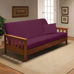 a red couch sitting on top of a wooden frame in a living room next to a window