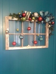 an old window with ornaments hanging on it