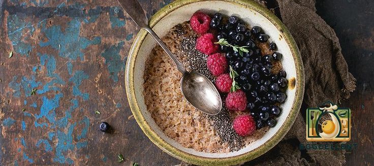 a bowl filled with oatmeal and berries on top of a wooden table