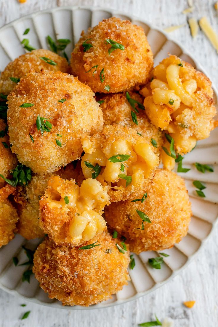 some fried food on a white plate with garnishes and parmesan cheese