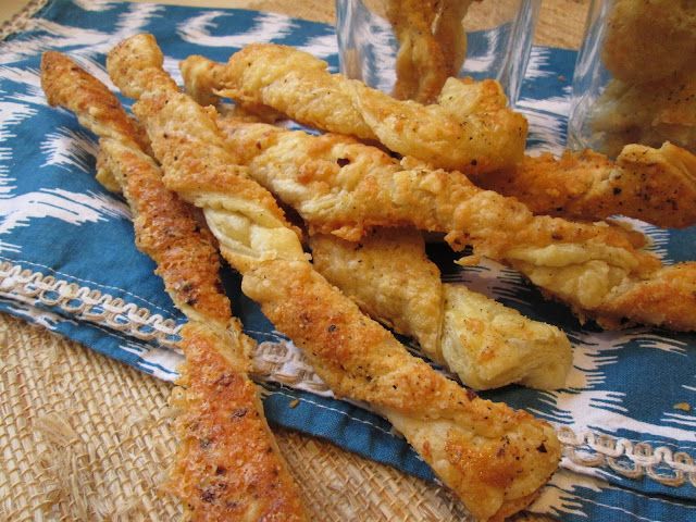 some fried food is on a blue and white cloth next to a glass with something in it