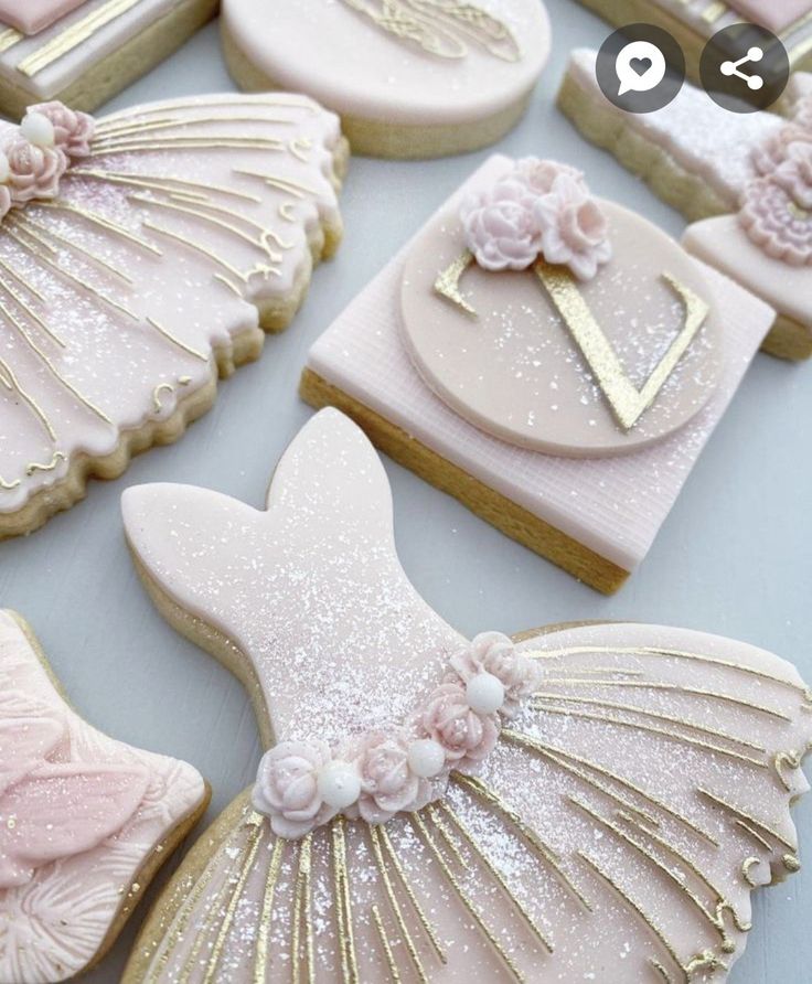 decorated cookies in the shape of seashells with pink and gold decorations on them