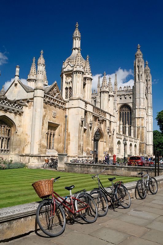 there are many bikes parked in front of the building with tall spires on it