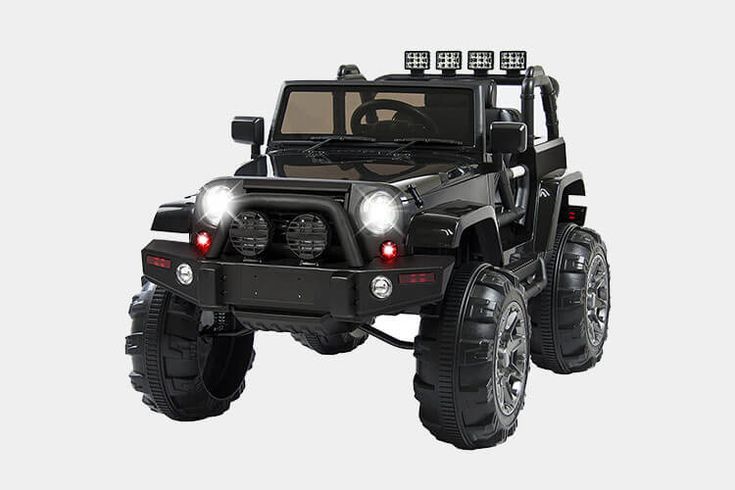 a toy jeep with lights on is in the middle of a white background and there are no people around it