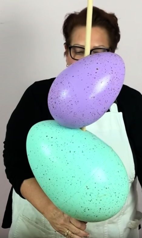 a woman holding two large balloons in her hands