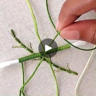 someone is working on something with green thread and scissors to make it look like an insect