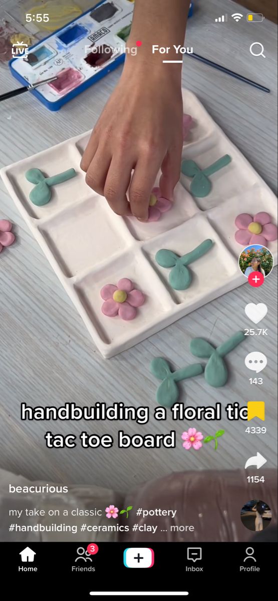 someone is placing flowers on the top of a board game with words above it that read, handbuilding a floral tic toe board