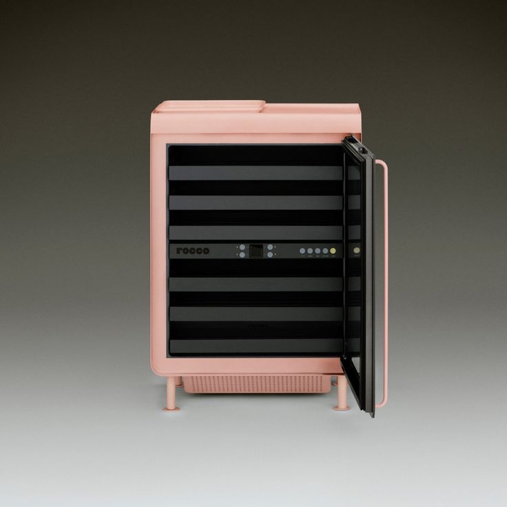 an open pink and black refrigerator on grey background