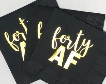 two black napkins with gold foil on them