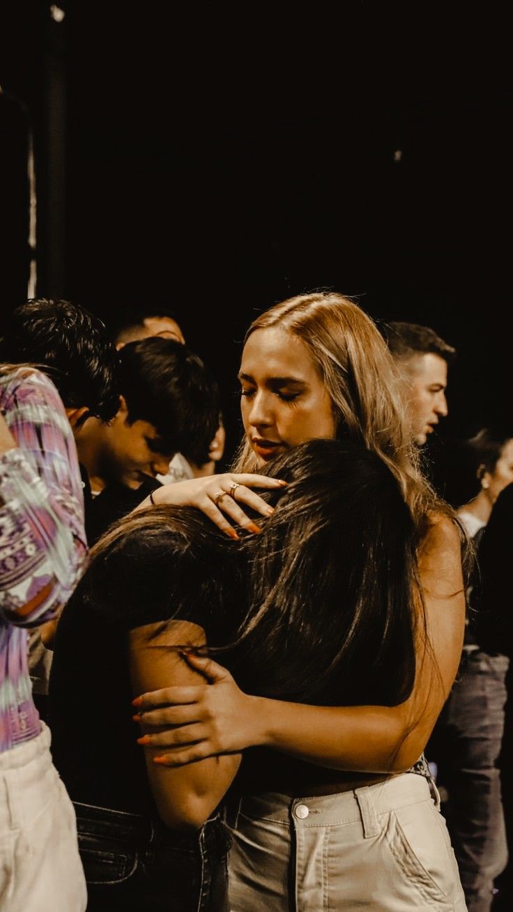 two women hugging each other in front of a crowd