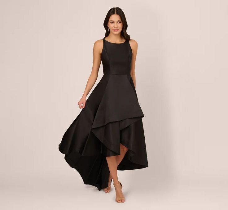 a woman is wearing a black dress with a high low heme and asymmetrical skirt