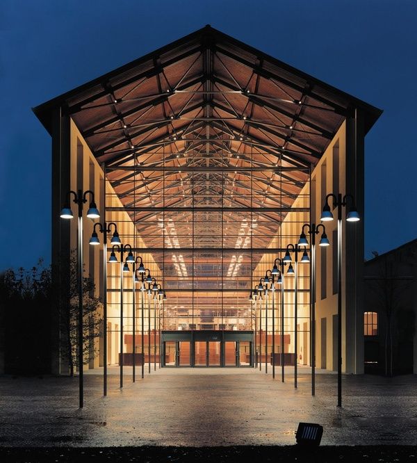 the inside of a building lit up at night with lights on and columns in front of it