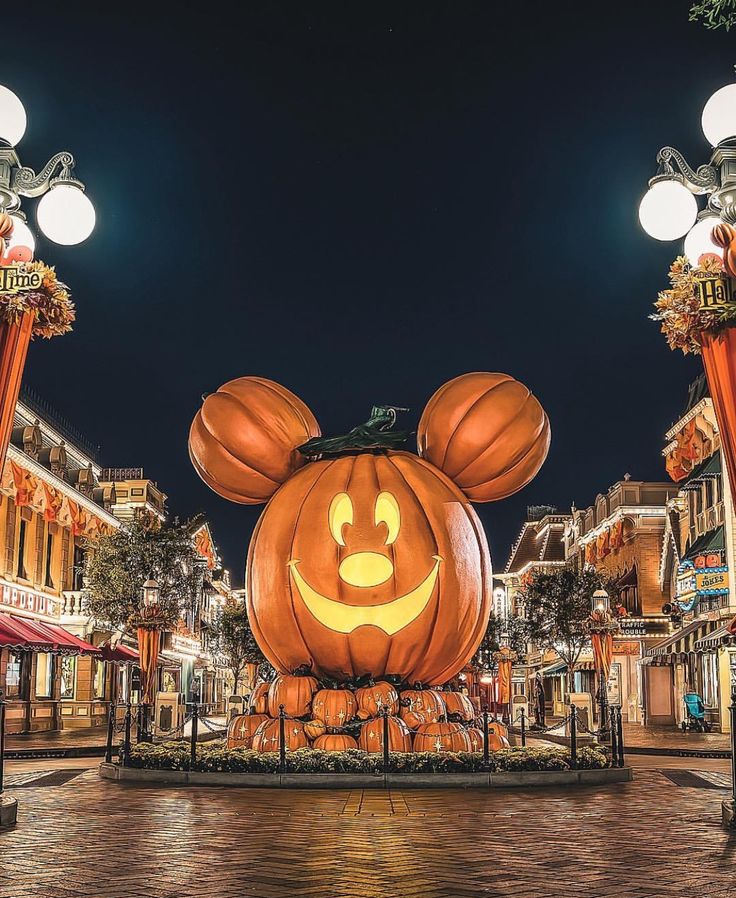 the entrance to mickey mouse's halloween town at night with pumpkins carved into it