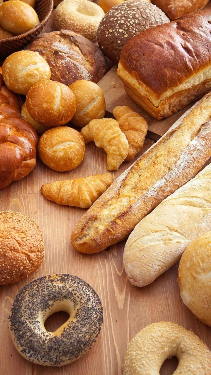 many different types of breads and pastries on a table