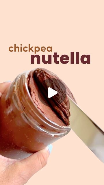 a person is holding a jar of nutella with a knife sticking out of it