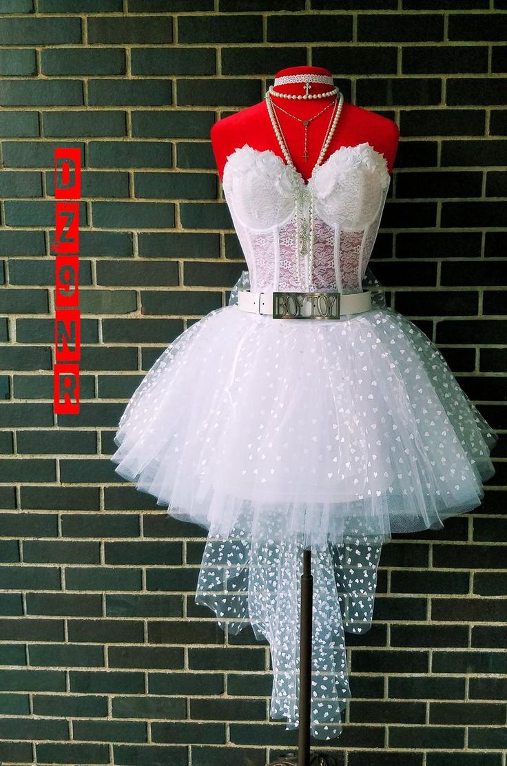 a mannequin dressed up as a dress with white polka dots on the skirt