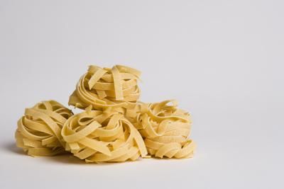 several uncooked noodles piled on top of each other in front of a white background