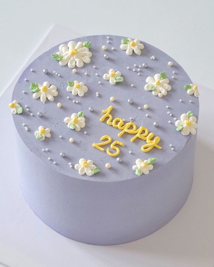 a blue cake with white flowers and the number twenty five on it's side