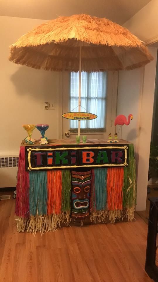 a tiki bar decorated with grass and straw umbrella