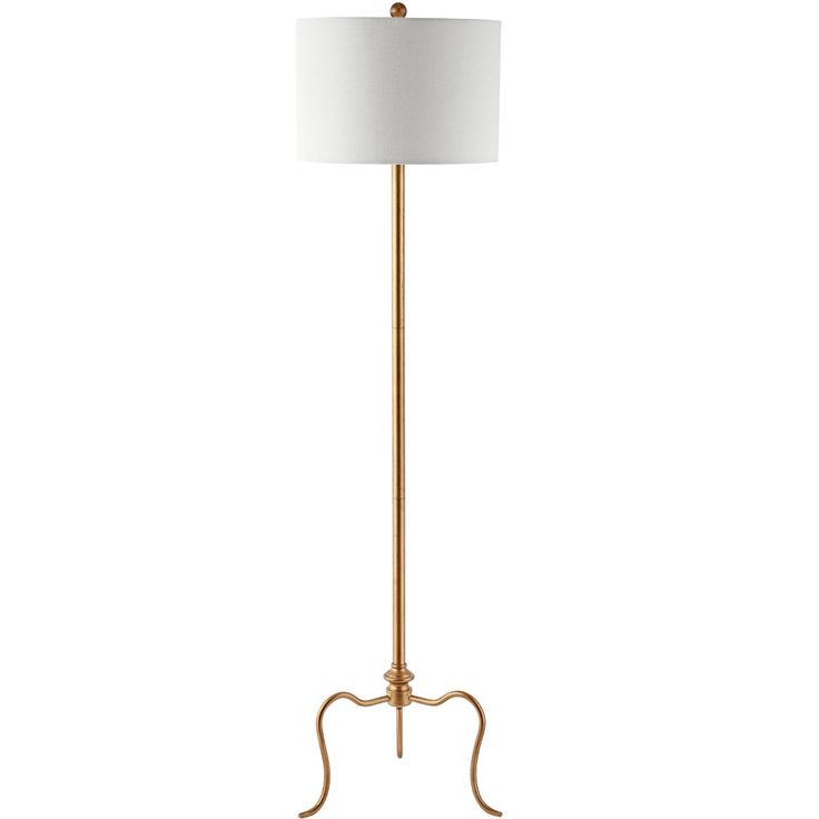 a gold floor lamp with a white shade on the top and an iron stand underneath it