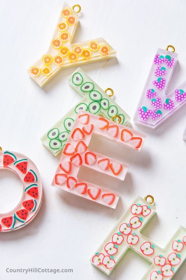 the letter e is made out of plastic and decorated with fruit slices, beads, and other items