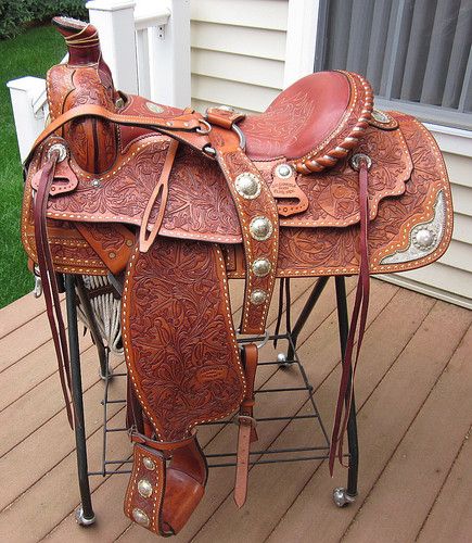 a saddle sitting on top of a wooden deck