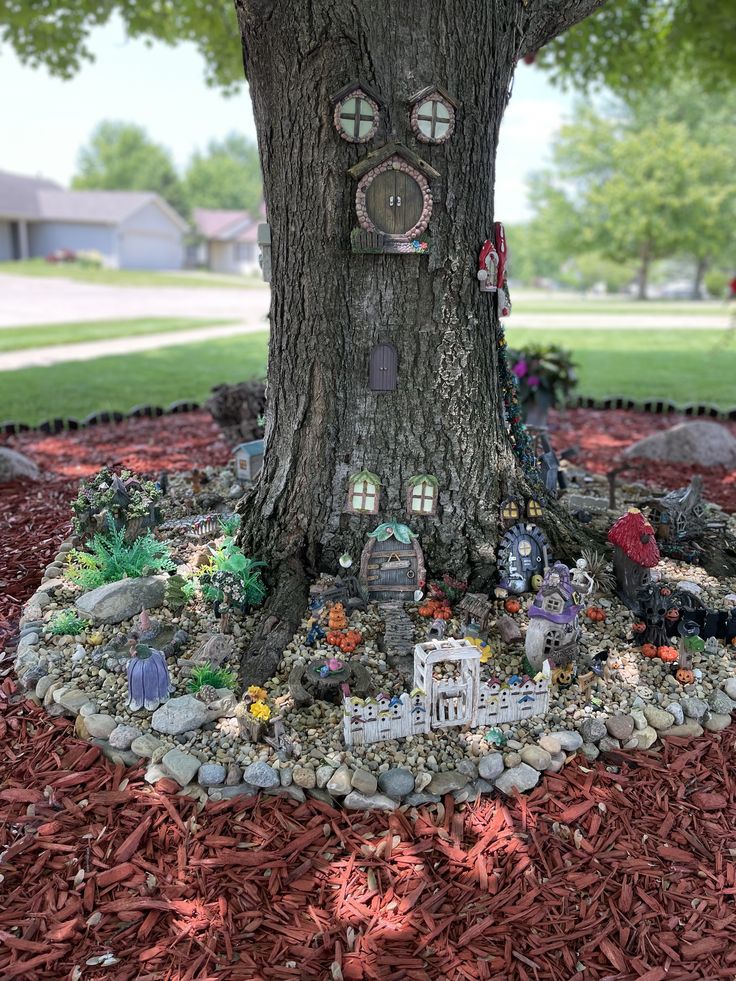 a tree with a clock built into it's face in the middle of a bed of mulch