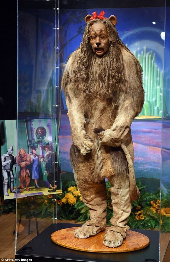 a statue of a bigfoot standing on top of a wooden platform in front of a glass case