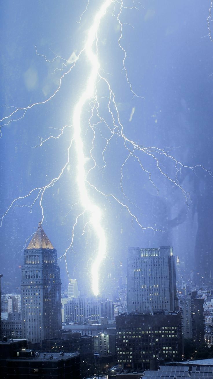 lightning strikes in the sky over a cityscape with tall buildings and skyscrapers