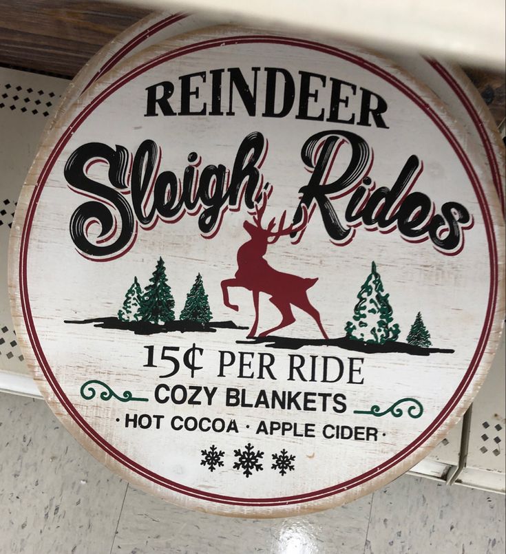 a sign that says sleigh rides with a deer on the front and trees in the back