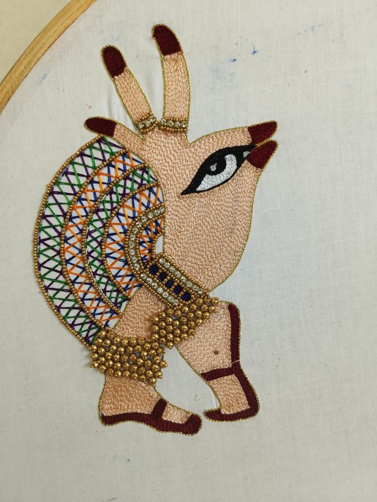 a close up of a embroidery on a piece of cloth with an animal in the middle