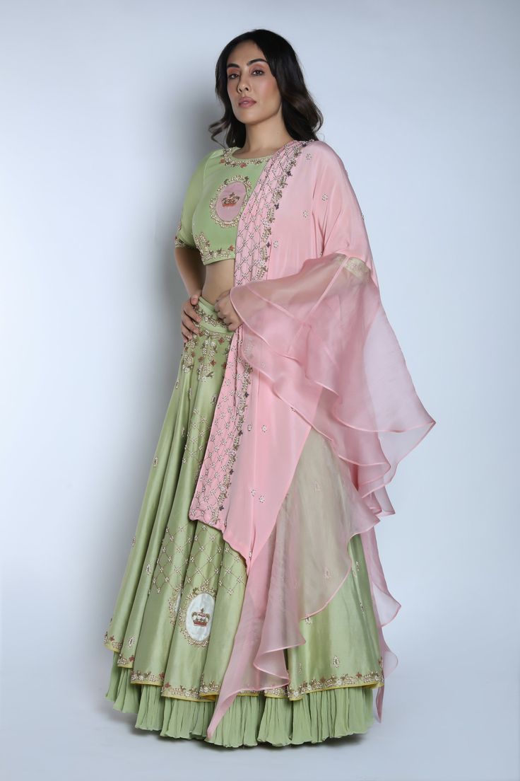 Editor's Note This set features a pista and blush pink crown embroidered two layered lehenga with crop blouse and ruffled dupatta. Neck: High Neck Sleeve Type: Half Sleeves Fabric: Chanderi Silk; Chiffon Care: Dry Clean Only Customize Your Outfit Can't find the size you're looking for? No stress. Just select size "Custom" while adding the item to your cart. We will follow up with you for your body measurements. To request a color or design customizations, please contact our customer care by usin Pink Georgette Sets With Cutdana, Pista Green Sets For Reception Navratri, Pista Green Sets For Reception And Navratri, Pista Green Sets For Reception During Navratri, Pista Green Lehenga With Gota Work, Pista Green Lehenga With Gota Work In Traditional Drape, Navratri Pink Set With Sheer Dupatta, Pink Georgette Sets With Traditional Drape, Unstitched Pista Green Lehenga With Gota Work