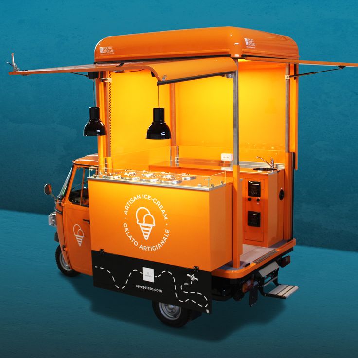 an orange ice cream cart with lights on it