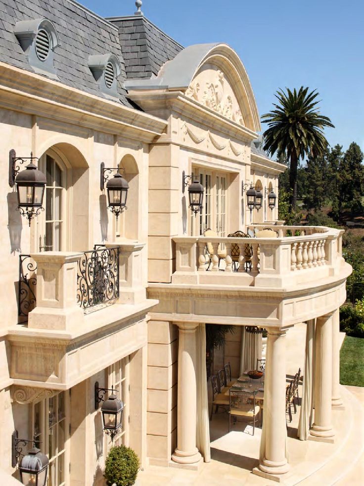 a large beige house with many windows and balconies