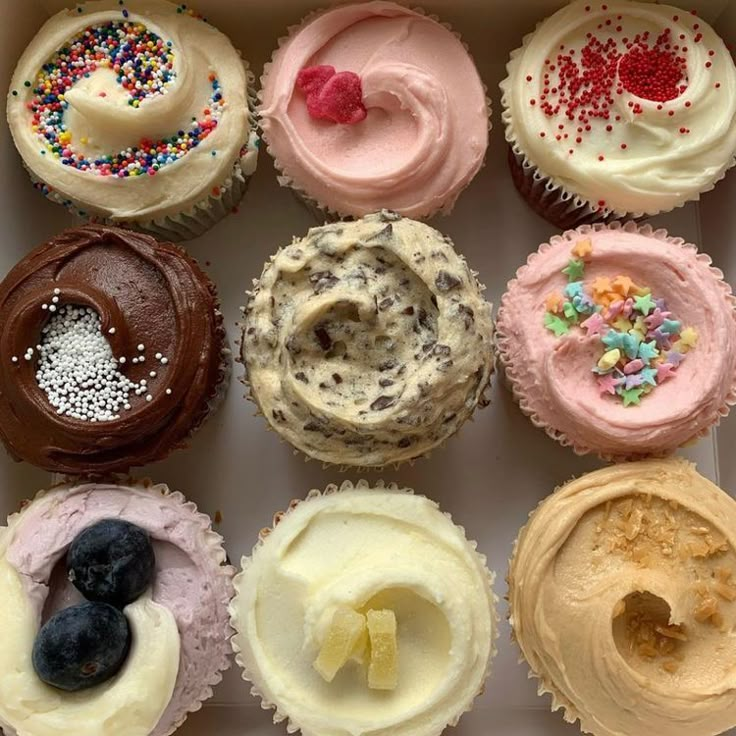 a box filled with lots of different flavored cupcakes