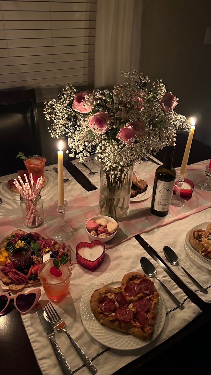 a table set with pizza, drinks and flowers