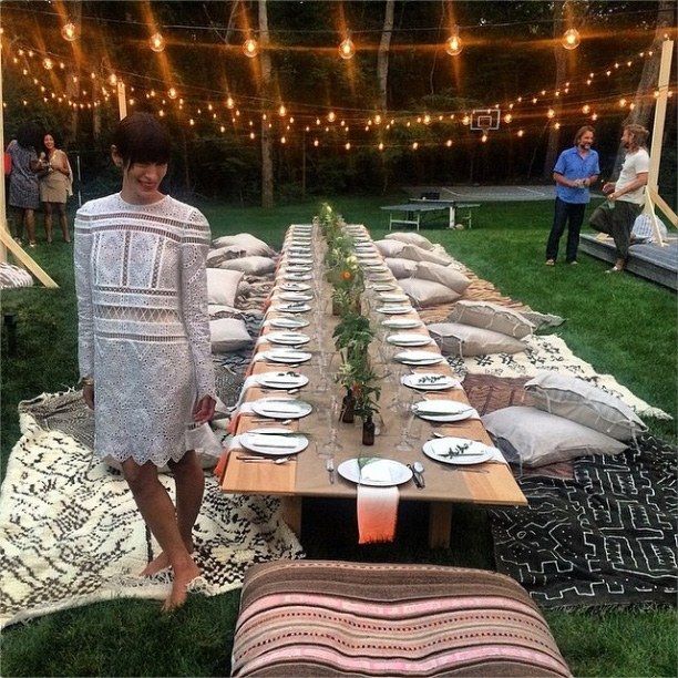 a woman standing next to a long table with plates on it