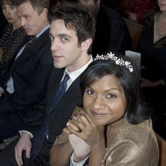 two people sitting next to each other at a formal event, one wearing a tiara