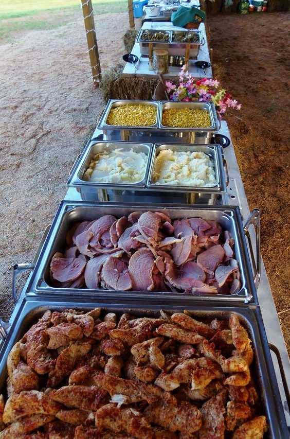 several trays of food are lined up on a table