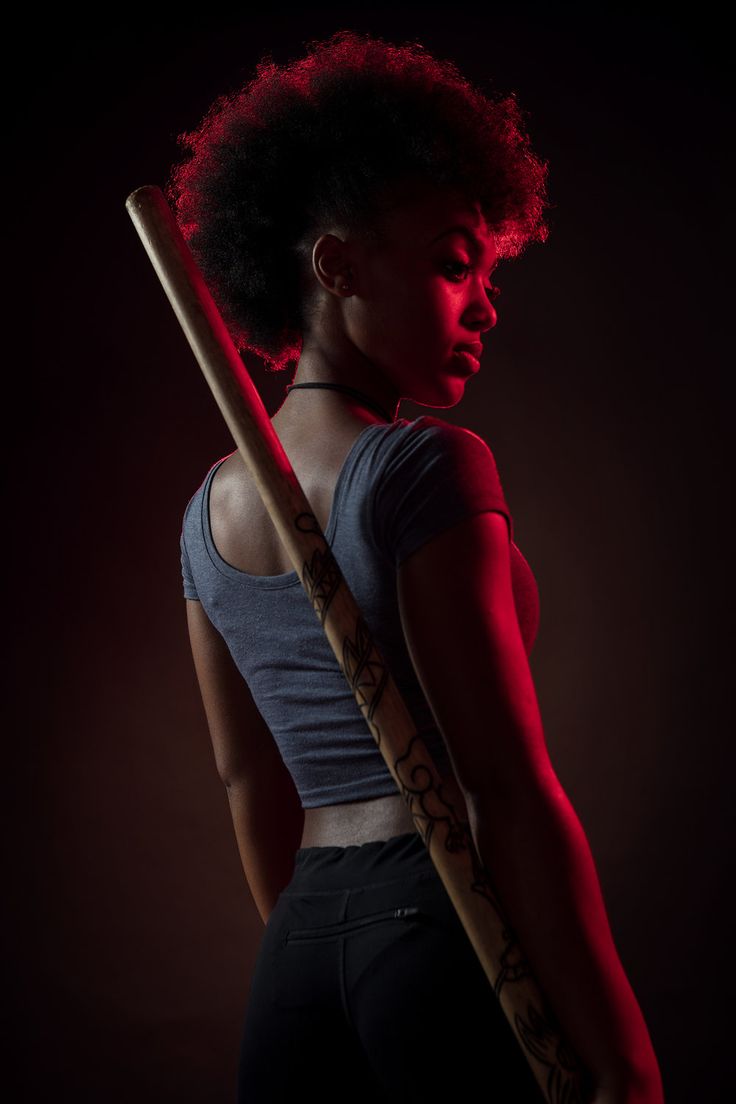 a woman holding a baseball bat in the dark