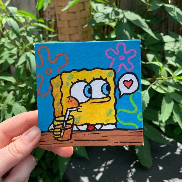 someone holding up a piece of art that looks like spongebob