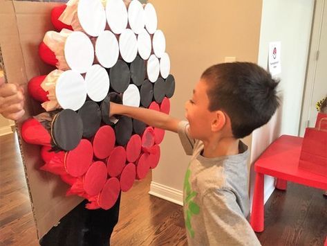 a young boy holding onto a cardboard box with hearts on it